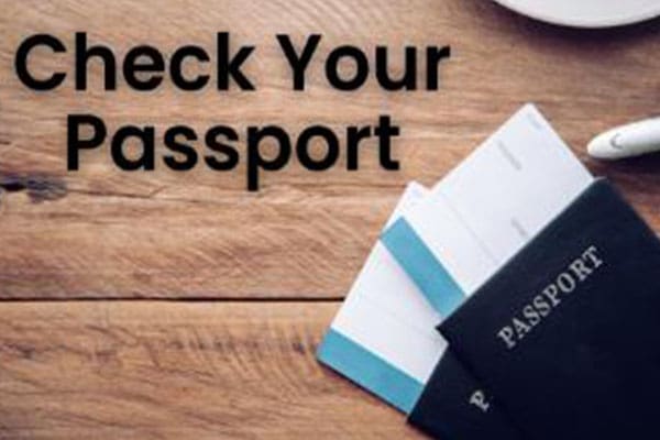 A wooden table with two passports and a cup of coffee.