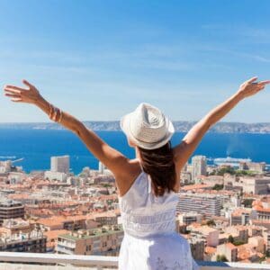 A woman in white shirt and hat standing on top of building.