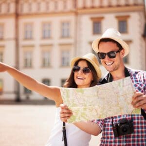 A man and woman holding a map in front of a building.