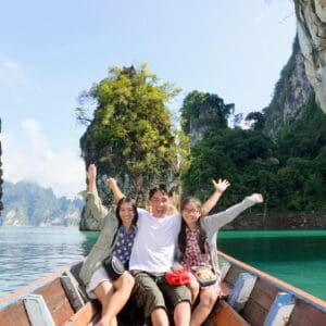 Three people are sitting on a boat in the water.