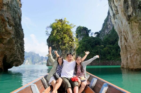 Three people are sitting on a boat in the water.