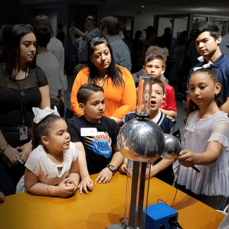 A group of people standing around a table.