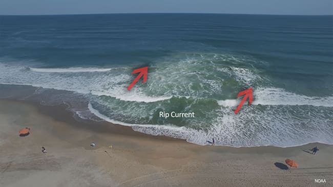 A surfer is riding the waves on his surf board.