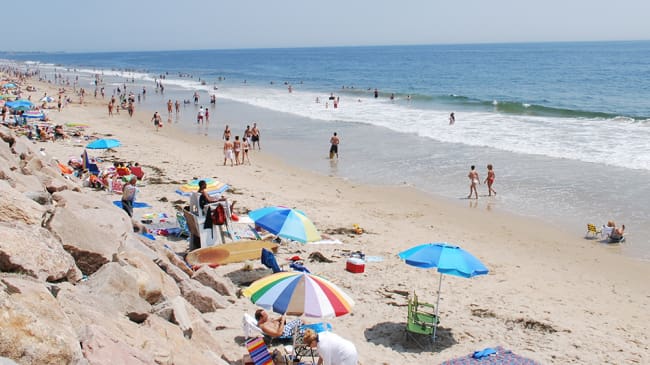 A beach with people and umbrellas on it