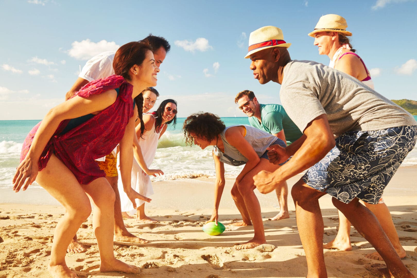 A group of people on the beach playing with a ball.